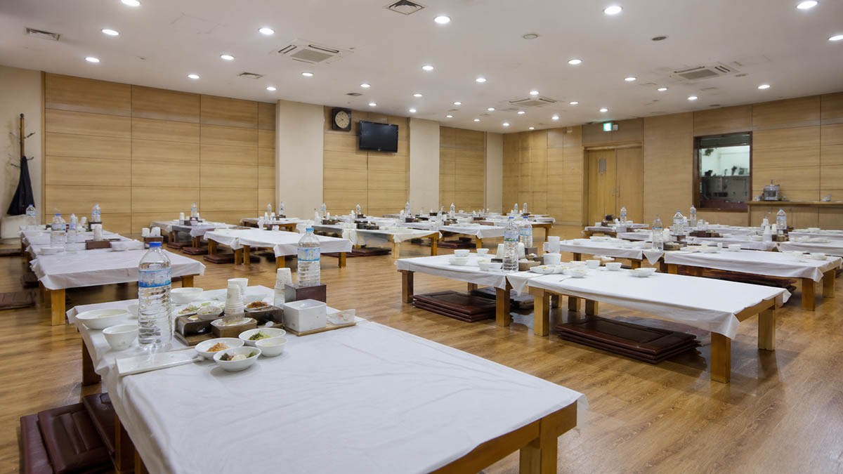 한국 장례식장 좌식 접객실에 낮은 상과 방석, 식사 그릇이 정리된 모습