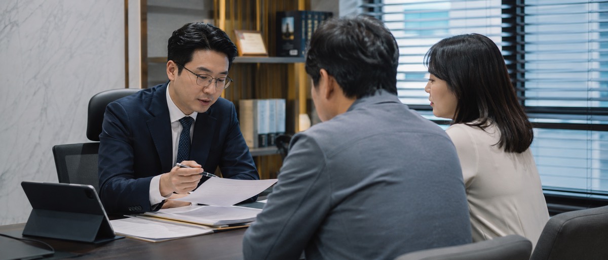 법률 상담 사무실에서 상속 관련 서류를 설명하는 전문가와 가족